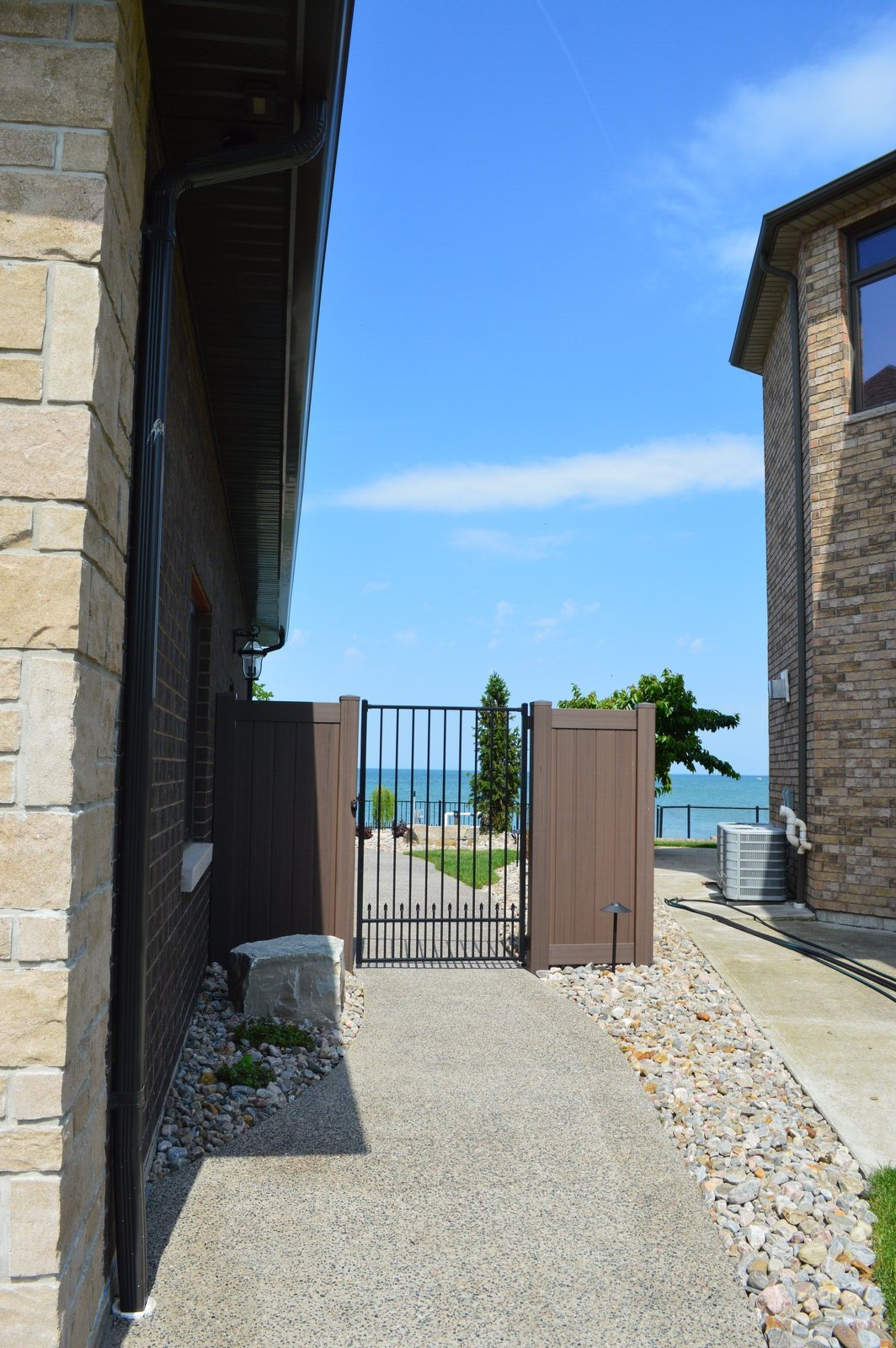 Vinyl gate with a welded aluminum frame powdercoated in matte black with Homeland chai grey infill